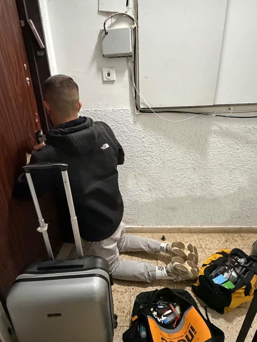 מנעולן מקצועי פורץ מנעול של דלת דירה נעולה בקריאת חירום